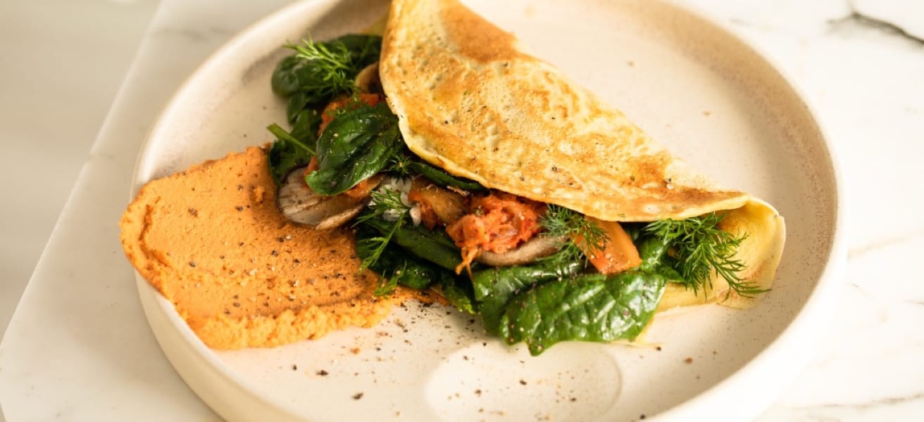 omelette with herbs and vegetables on a white plate